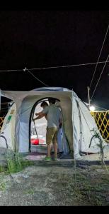 GulmitBaseet Camping and Restaurant的一个人晚上站在帐篷里