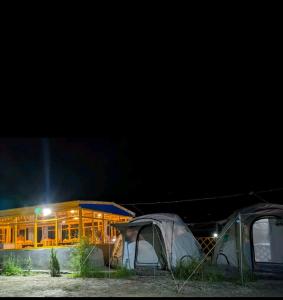 GulmitBaseet Camping and Restaurant的两个帐篷在晚上在大楼前