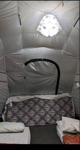 GulmitBaseet Camping and Restaurant的帐篷配有两张床和一盏灯