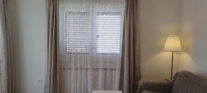 莫什尼卡德拉加Apartments Villa Elma的窗户配有白色窗帘、椅子和灯