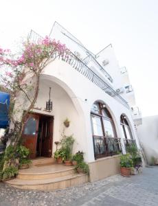 凯里尼亚Kyrenia British Harbour Hotel的前面有盆栽植物的白色建筑