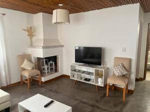 圣卡洛斯La Puerta Azul San Carlos的客厅配有平面电视和椅子