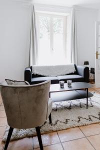 拉弗雷切Maison Madeleine的客厅配有沙发、桌子和椅子