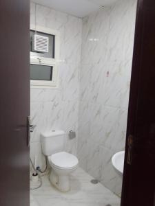 沙迦الخورى تاور的白色的浴室设有卫生间和水槽。