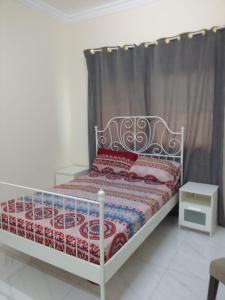 沙迦الخورى تاور的一间卧室配有一张带红色和白色棉被的床