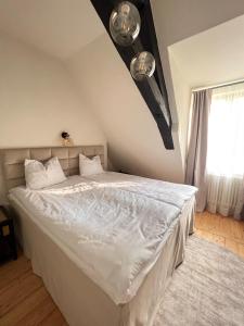 斯伽尔达Rezidence Wannas Self Check in的一间卧室配有一张带白色床单的床和一扇窗户。