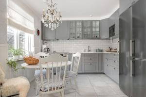 维斯比Visby city Apartments的厨房配有灰色橱柜和桌椅