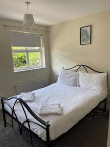 惠灵顿House number 4 Sleeps up to 5 with Smart TVs in every room的一间卧室配有一张带白色床单的床和一扇窗户。