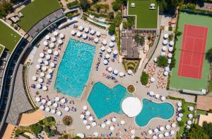 依克希亚奥林匹克皇宫酒店的享有带桌子和遮阳伞的游泳池的顶部景致
