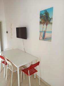 特拉尼Enjoy Trani的一张带椅子的白色桌子和墙上的电视