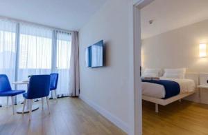 巴统Orbi City Hotel Group Batumi的卧室配有一张床和一张桌子及椅子