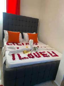 蒙巴萨Davkin Apartments的一张床上有红色玫瑰花瓣的床
