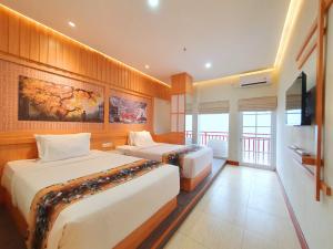 日惹Little Tokyo的酒店客房设有两张床和一台平面电视。