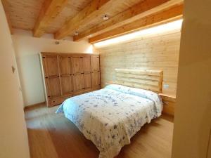 马斯诺维斯康蒂Bella Italia chalet的一间卧室设有一张床和木墙