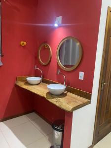 巴雷里尼亚斯Hostel Flor de Ipê的浴室设有两个水槽和红色的墙壁