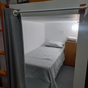 巴雷里尼亚斯Hostel Flor de Ipê的配有窗帘的小客房内的双层床
