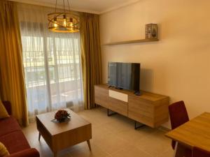 卡尔佩PLAZAMAYOR的客厅配有平面电视和桌子。