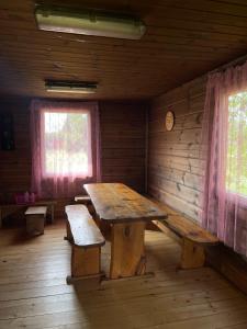 扎拉赛Česlovos sodyba的小屋内带木桌和长凳的房间