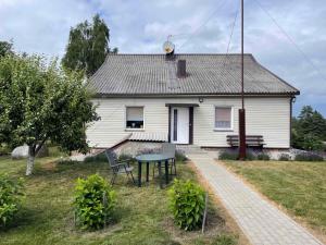 扎拉赛Česlovos sodyba的前面有一张桌子的白色房子