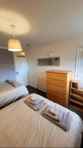 卢顿4 Bedroom 4 En Suite House Close to A5 & Whipsnade的酒店客房带两张床和梳妆台