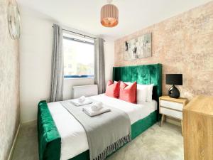 伦敦WEEKLY OR MONTHLY STAY - Relocation & Business - 4 Guests - By Hofin Stays Short Lets & Serviced Accommodation的一间卧室配有一张大床和红色枕头
