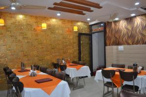 阿格拉Hotel Jigyasa By Mayda Hospitality Pvt. Ltd.的一间带桌椅的用餐室和一面墙