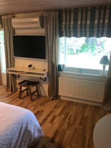 胡丁厄Private space with 2 bedrooms的一间卧室配有电视、一张床和一个窗户。