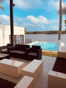 阿西尼Villa Assinie Bord de Lagune的带沙发的庭院和游泳池