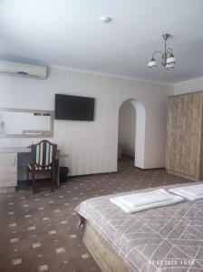 卡缅涅茨-波多利斯基Apart-hotel 24/7的一间卧室配有一张床、一把椅子和电视
