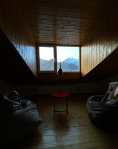 卡兹贝吉Mansarda Kazbegi的客房设有两张床和一扇山景窗户。