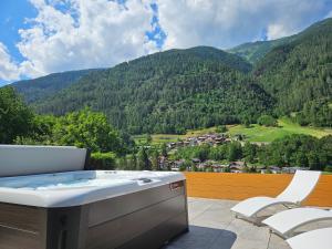 科姆梅扎杜拉Hotel Genzianella的山景阳台上的热水浴池