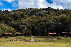 康赛瓦托利亚Recanto da roça的山前带桌子和遮阳伞的公园