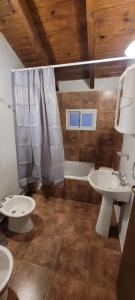 拉安戈斯图拉镇Blue House 5 Villa La Angostura的浴室配有2个盥洗盆、淋浴和浴缸。