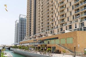 阿布扎比Your Luxurious 2BR Al Reem Escape at Mangrove Place的一座大建筑,毗邻一条河,有建筑物