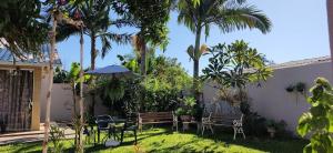 伊瓜苏Family Comfort, Casa residencial Aconchegante的后院配有桌椅和棕榈树