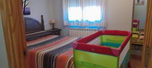 Valbona艾尔普拉多公寓的儿童卧室,配有一张带婴儿床的床