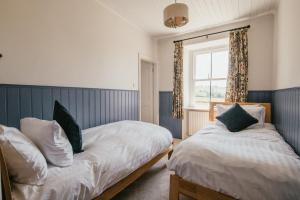 马勒姆Miresfield Farm Bed & Breakfast的一间卧室设有两张床和窗户。