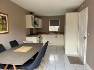 格洛斯特Large 2 bedroom apartment, 4 beds one 1 en-suite, Free parking Nr Chelt Elmore and Quays的厨房配有桌子和蓝色椅子