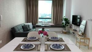 八打灵再也NEW Sunway Greenfield Home 2-6pax 5mins to Sunway Pyramid的客厅配有桌子和沙发