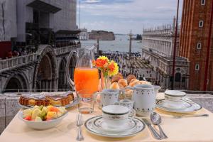 威尼斯Canaletto Luxury Suites - San Marco Luxury的餐桌上摆放着食物和饮料,享有美景