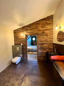 奥普La cabane de babarot的浴室设有木墙、卫生间和床。
