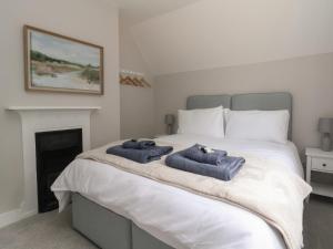 诺斯维奇2 Golf Links Cottages的一间卧室配有一张床,上面有两条毛巾