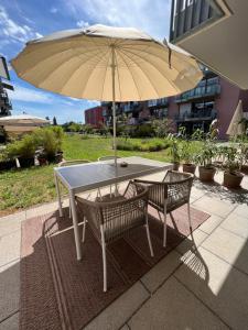 康斯坦茨Urban Lodges - Studio Apartments am Seerhein的一张桌子和两把椅子及雨伞