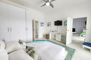 东伦敦Blue's Guest House - East London Bonza Bay的白色的客房配有床和电视。