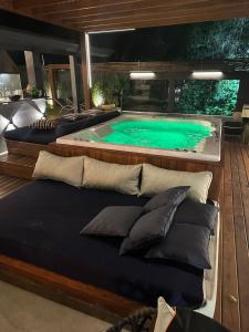 朱奎Casa térrea com acessibilidade em Juquehy com piscina aquecida e hidromassagem的甲板上设有几个枕头的游泳池