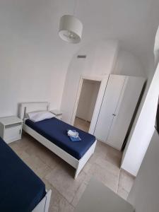 焦维纳佐Dimora San Michele的白色的客房配有一张床和白色的橱柜。