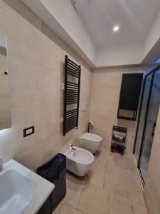 焦维纳佐Dimora San Michele的一间带水槽和卫生间的浴室以及一台电视。