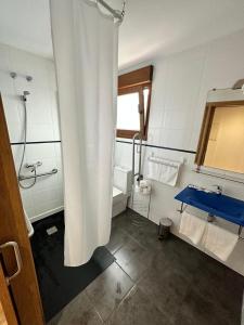 桑亨霍Top Sanxenxo Resort的浴室配有淋浴帘、浴缸和盥洗盆。