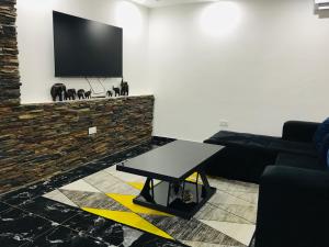 卢萨卡Batoka Apartments的客厅配有桌子和平面电视。