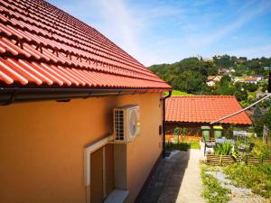采列Small house in Celje的橙色的房子,设有红色的屋顶和庭院